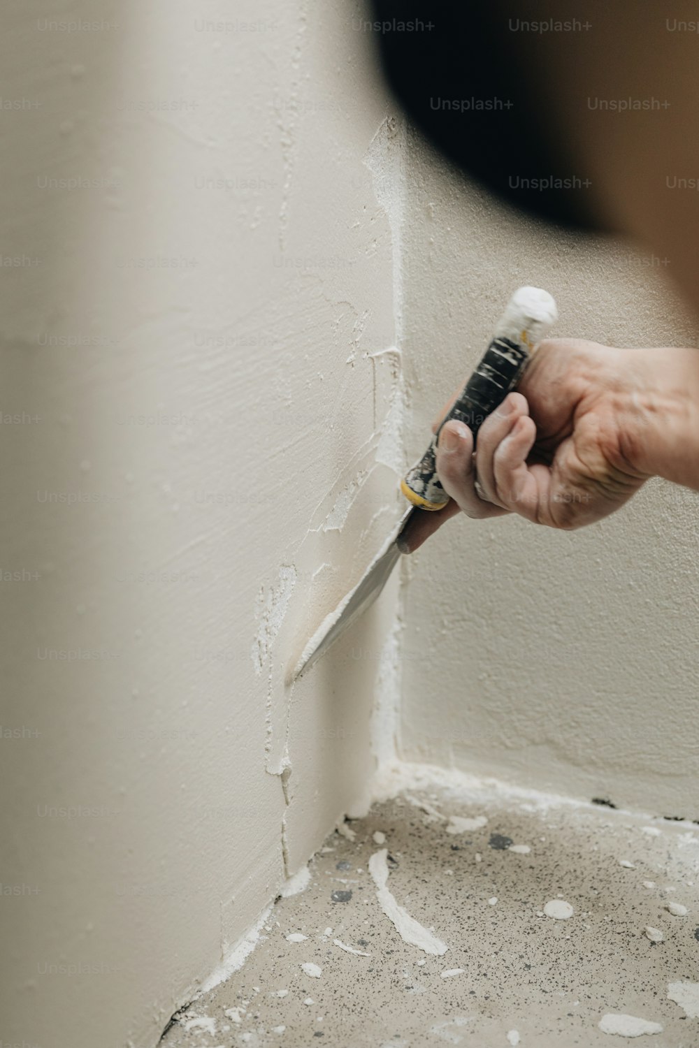 eine Person, die einen Pinsel benutzt, um eine Wand zu streichen