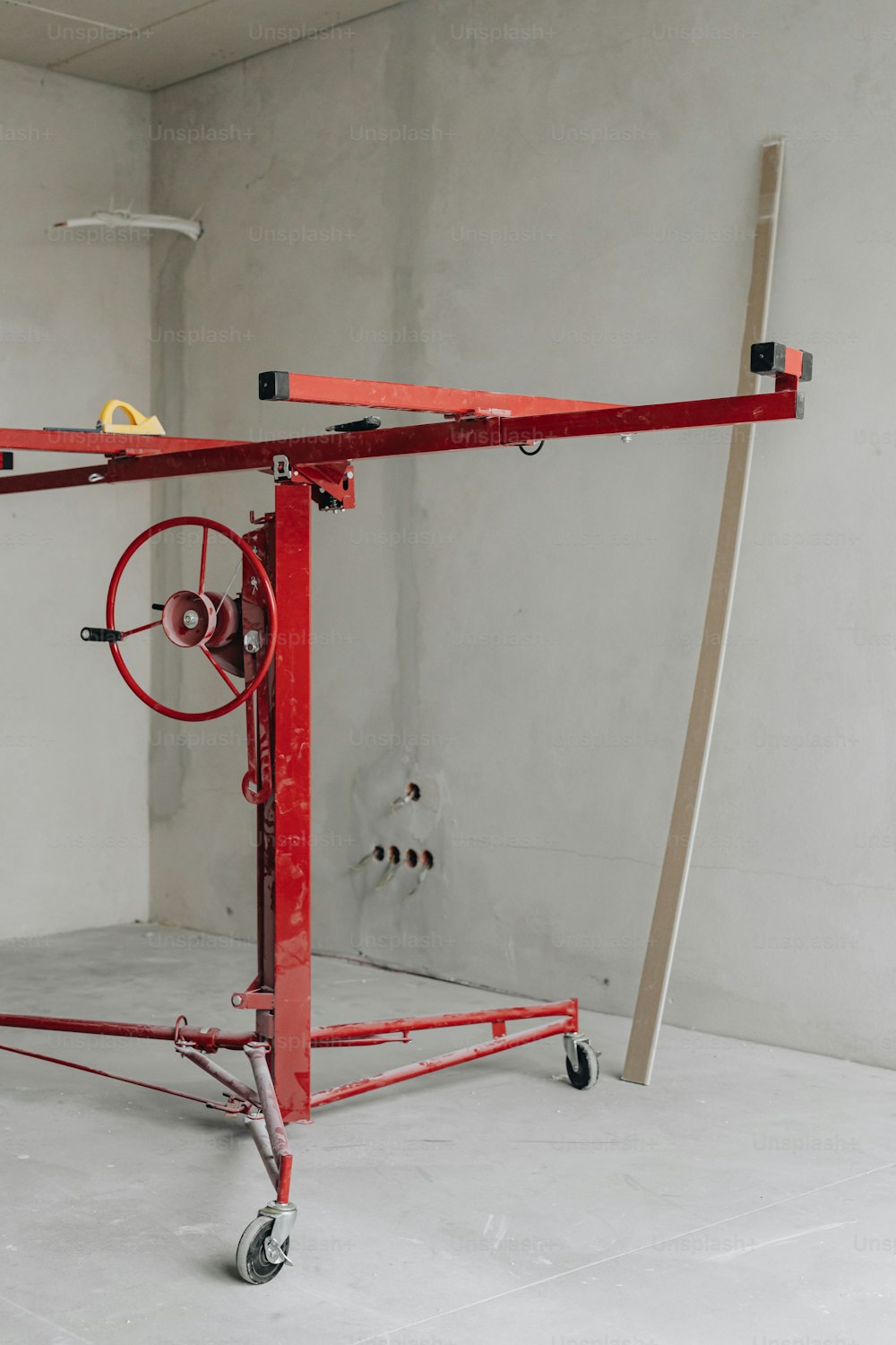 a red work stand with wheels and a handle