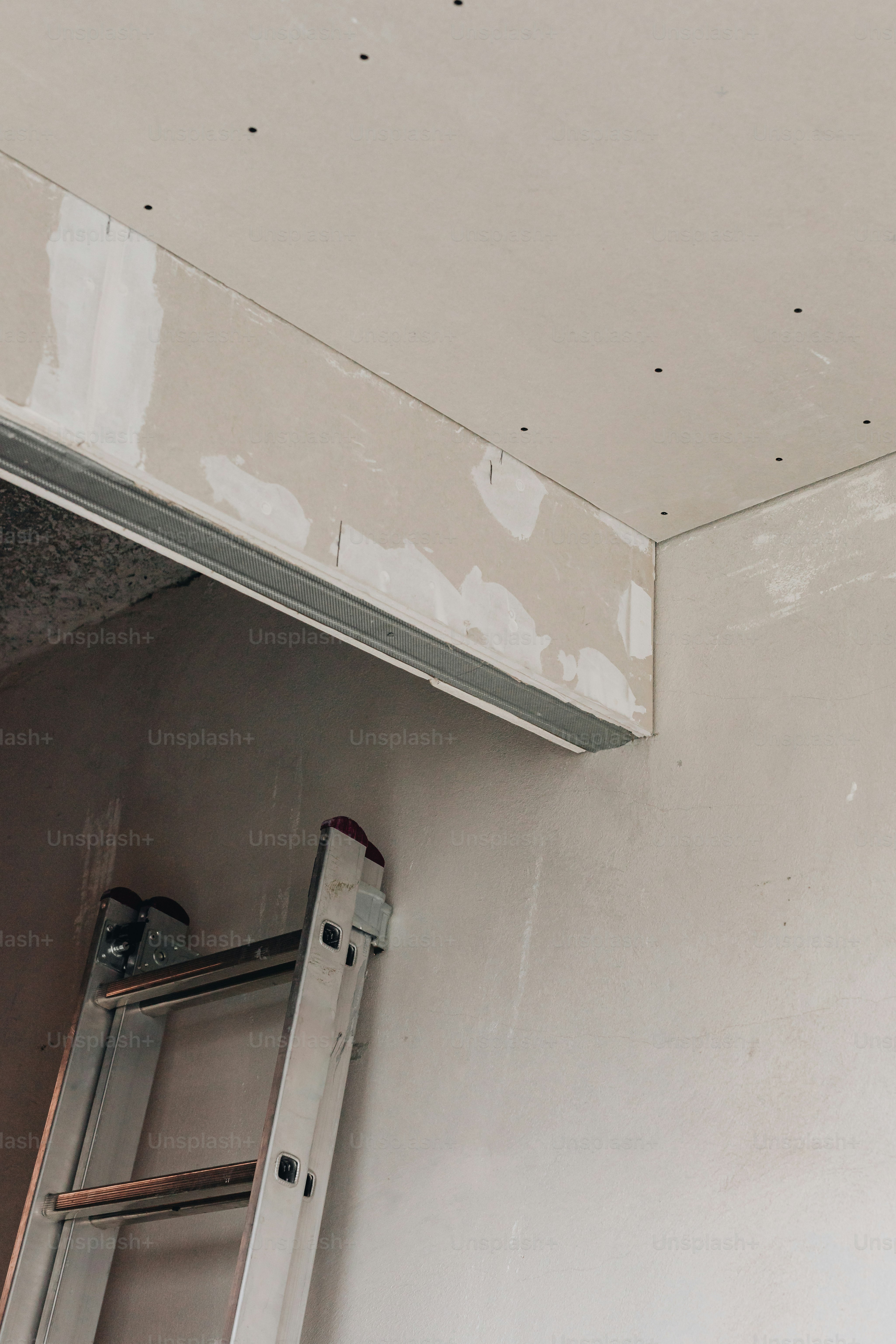 eine Leiter, die an eine Wand neben einem Fenster gelehnt ist