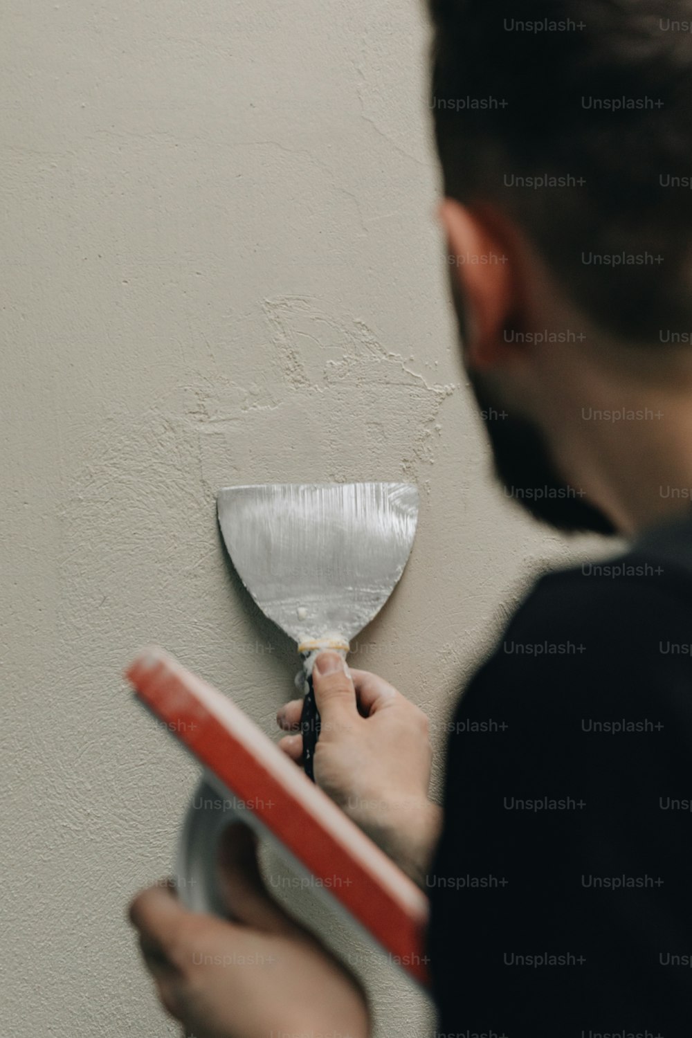 a person using a paint roller to paint a wall
