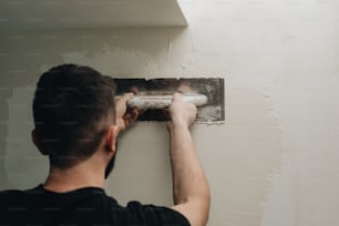 a man working on a light switch in a room