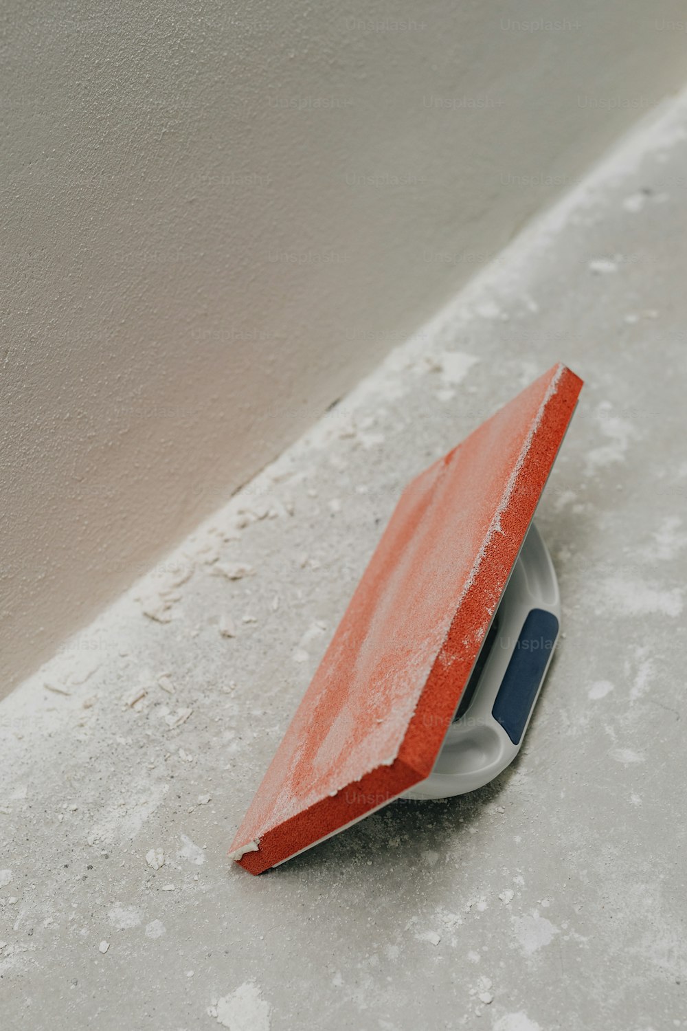 a red and white object sitting on top of a cement floor