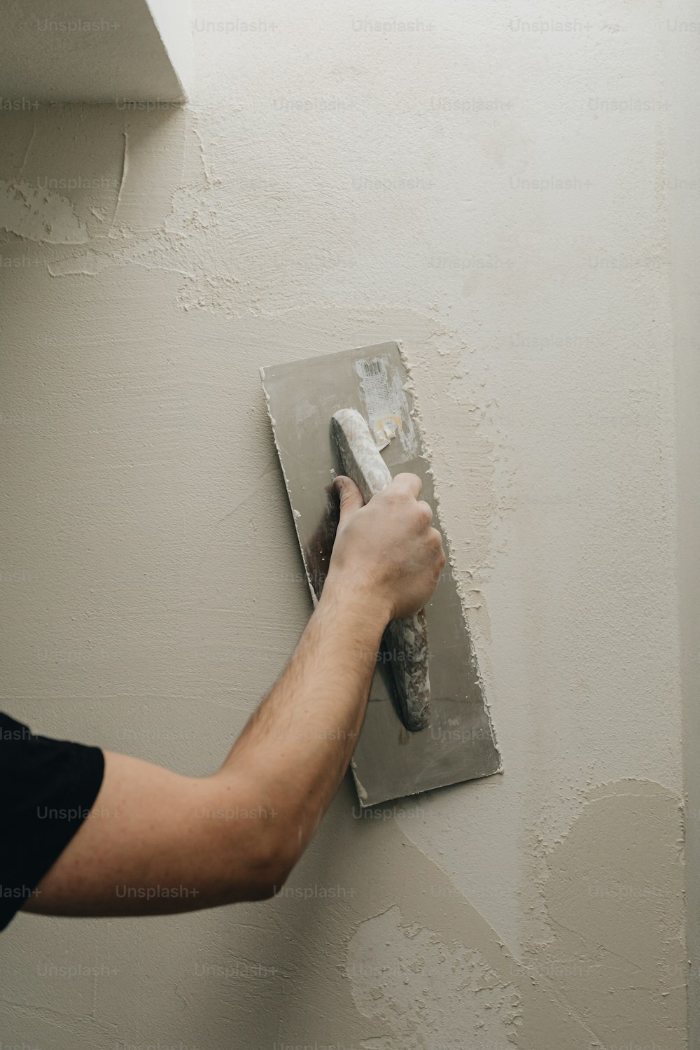 a man is painting a wall with a paint roller