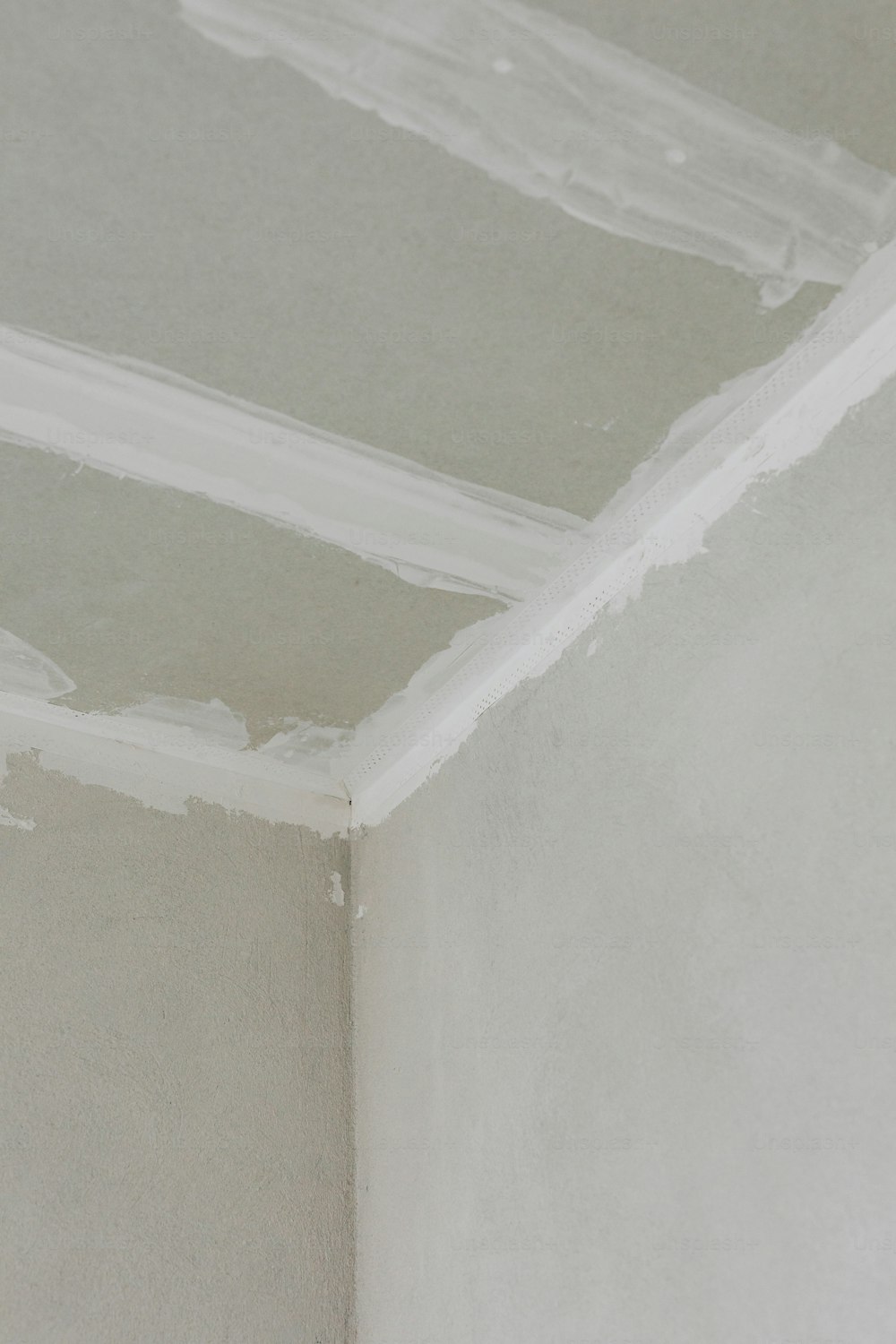 a corner of a room with white paint on the walls