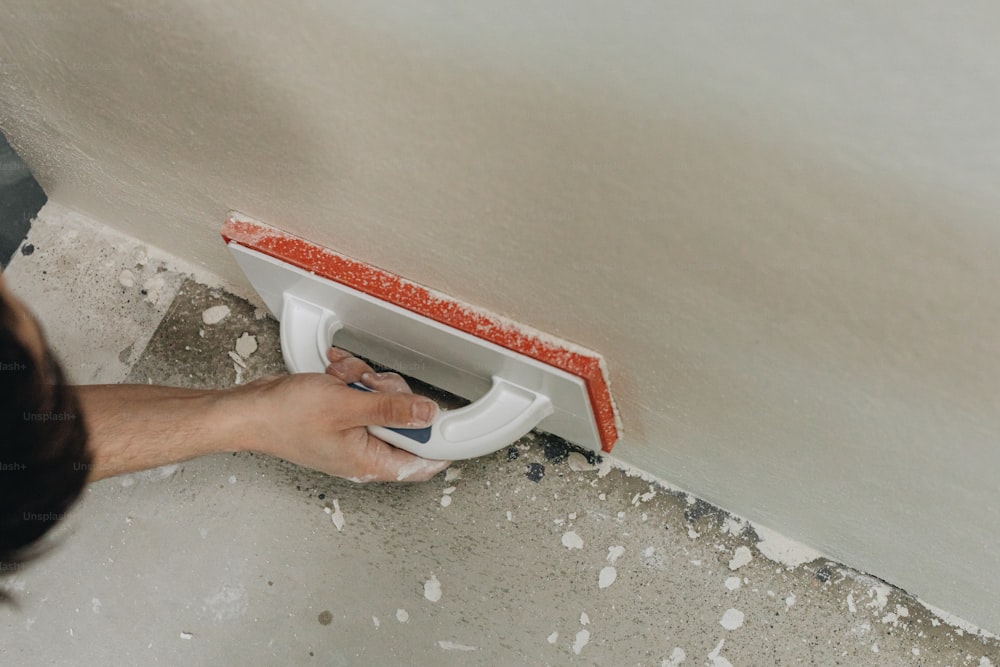 a person using a tiler on a wall