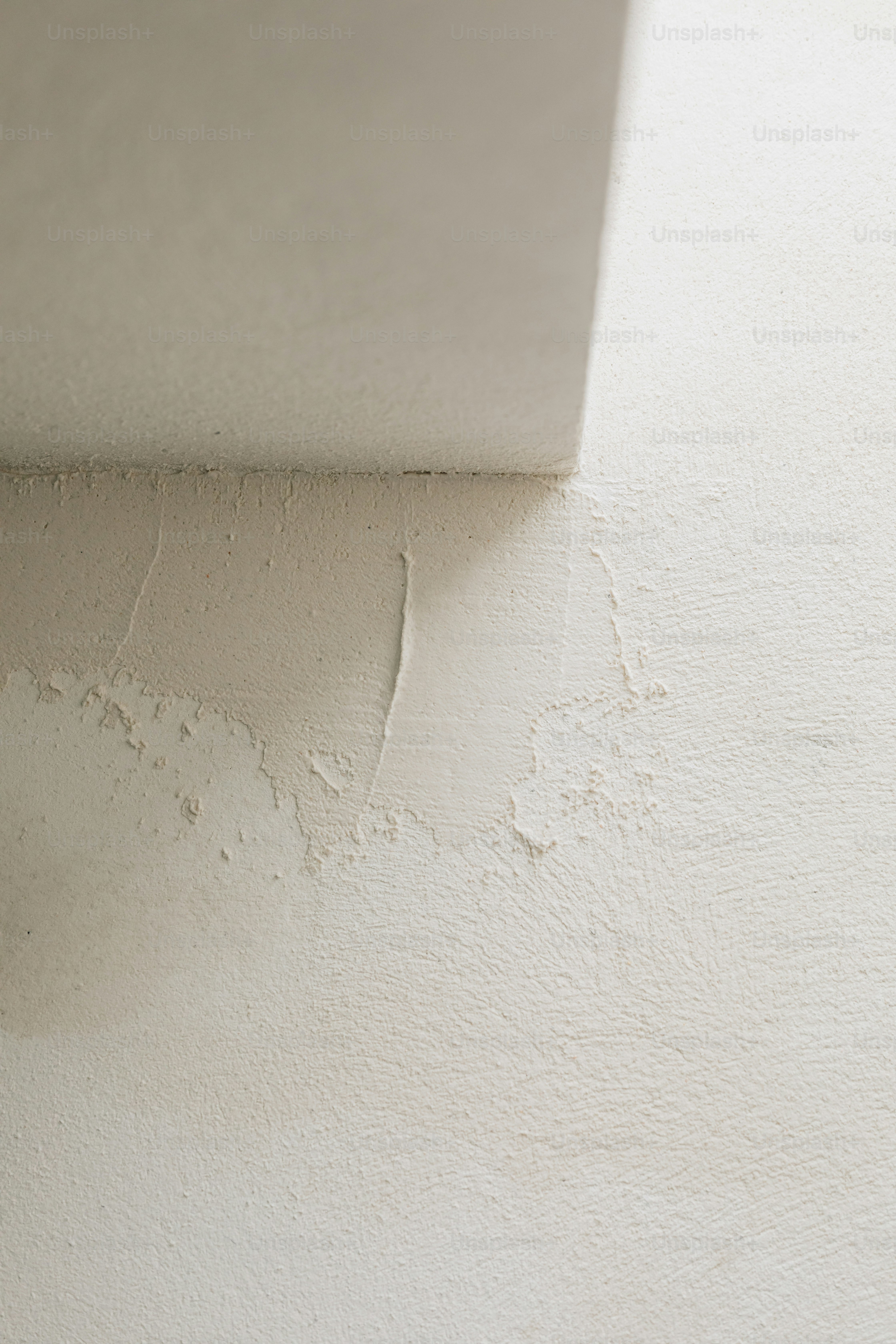 a corner of a white wall with some paint on it