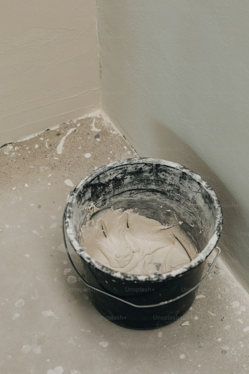 a bucket of white paint sitting on the floor