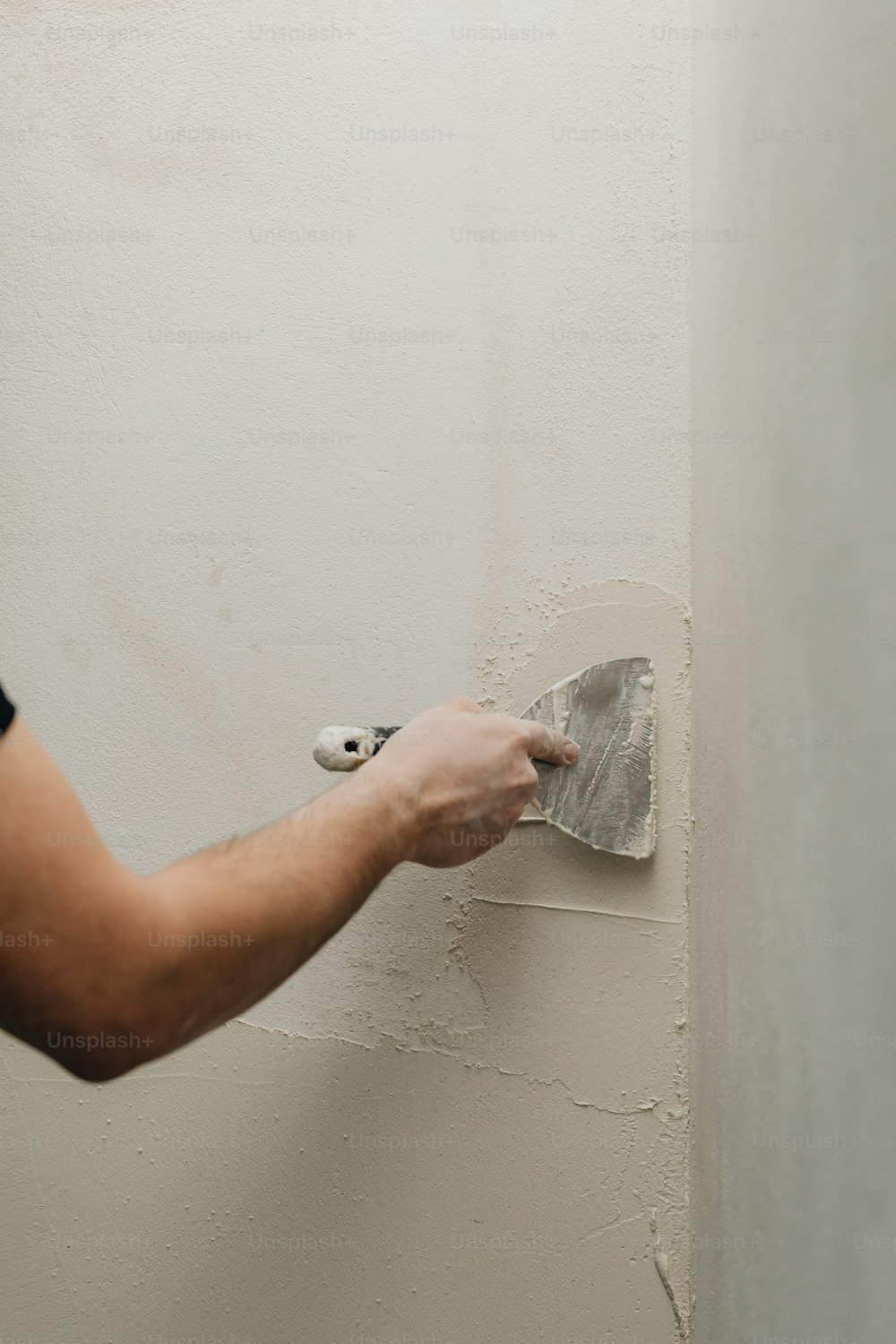 a person using a paint roller to paint a wall