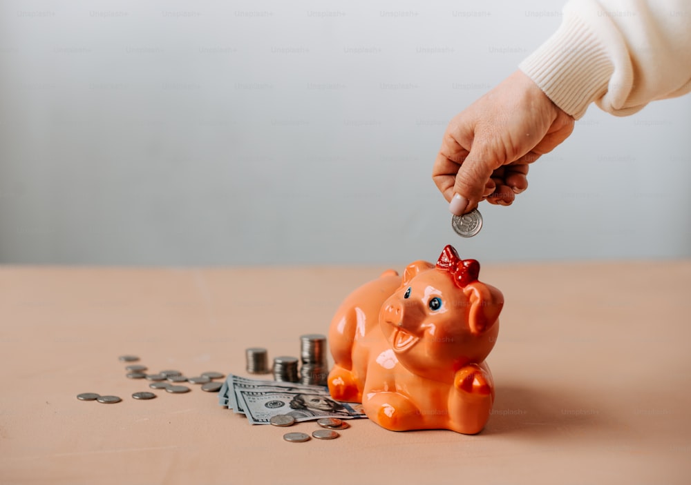 a person putting a coin into a piggy bank