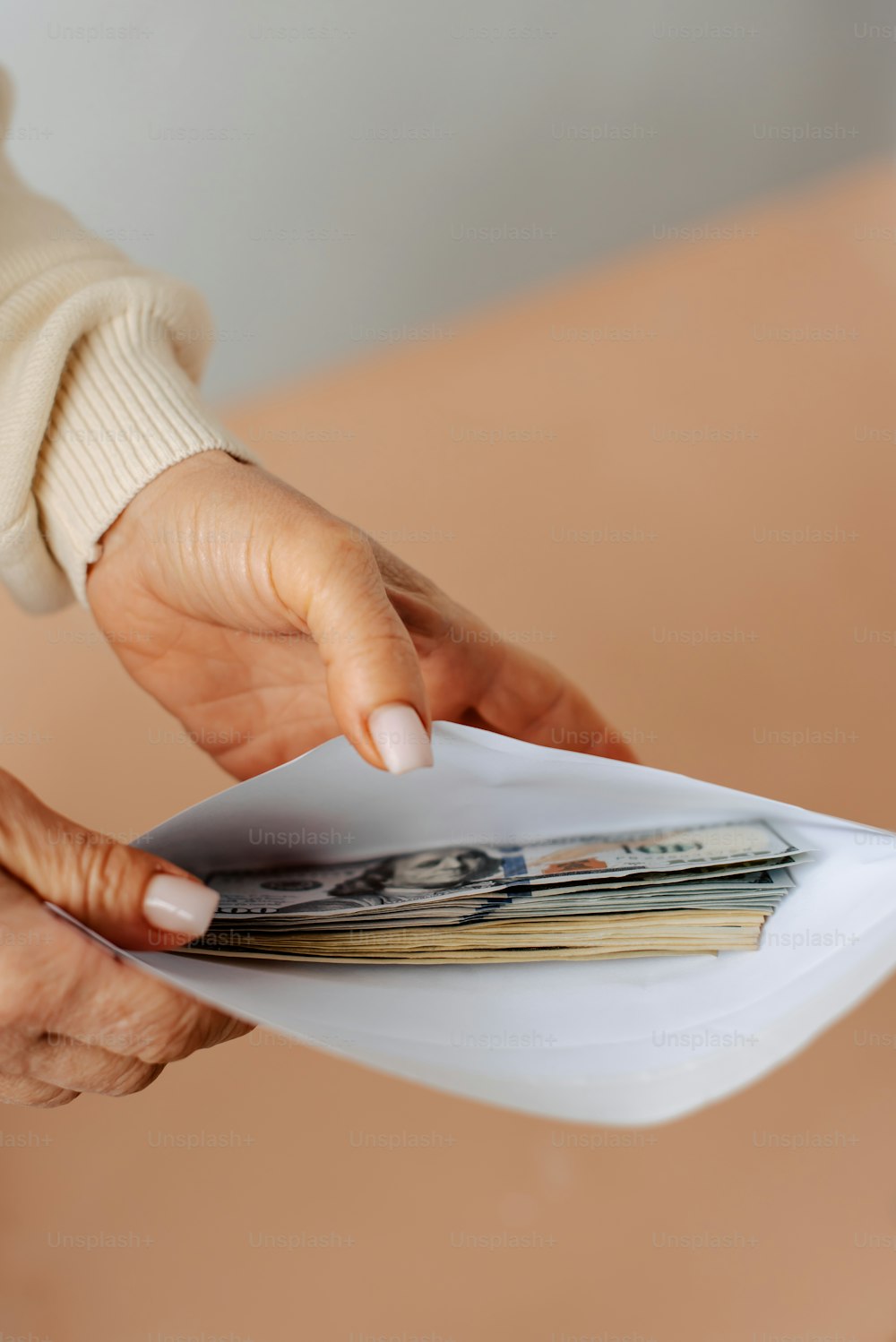 Una mujer sosteniendo una pila de dinero en la mano