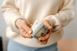 a woman holding a stack of money in her hands