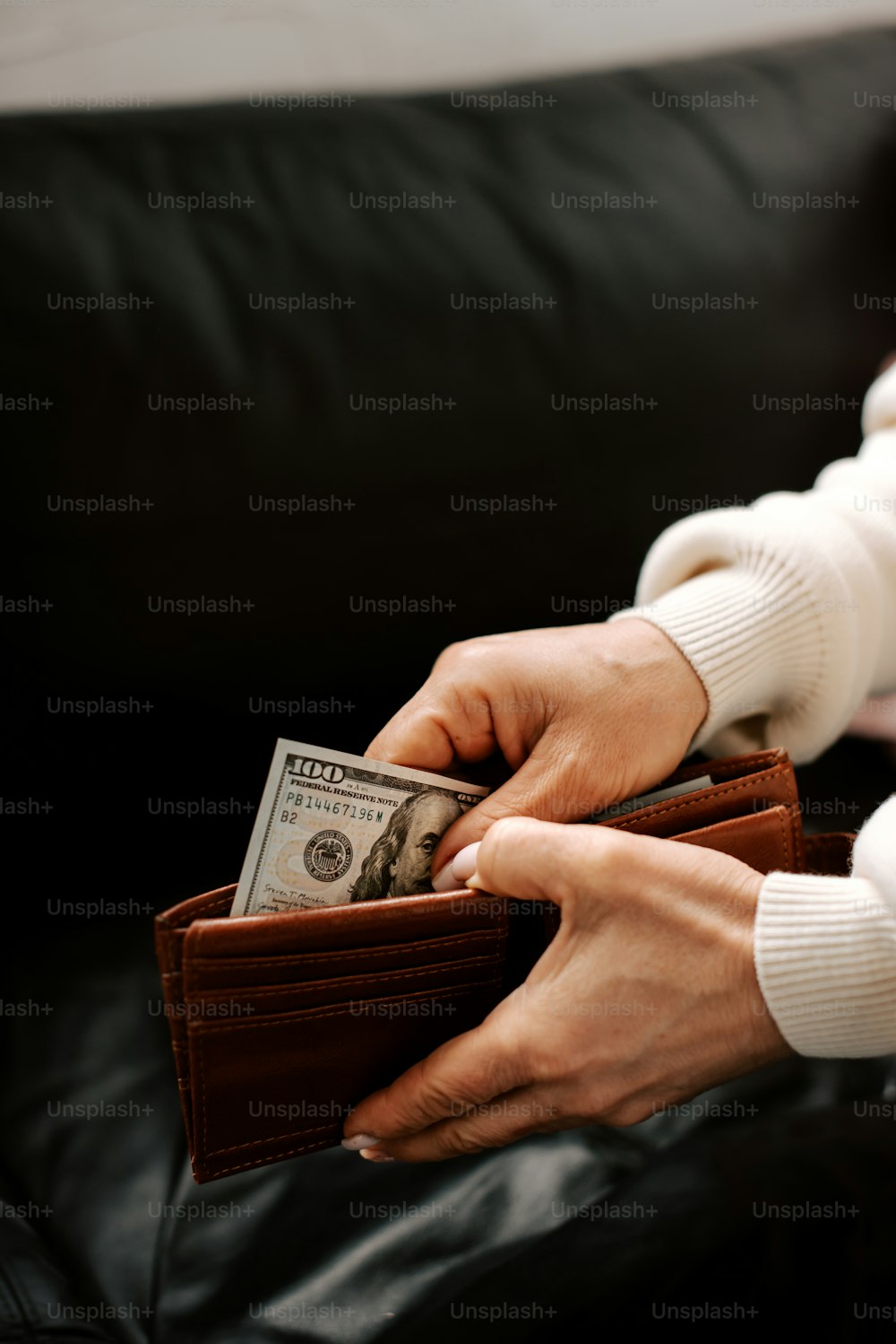 a person holding a wallet and money in their hands