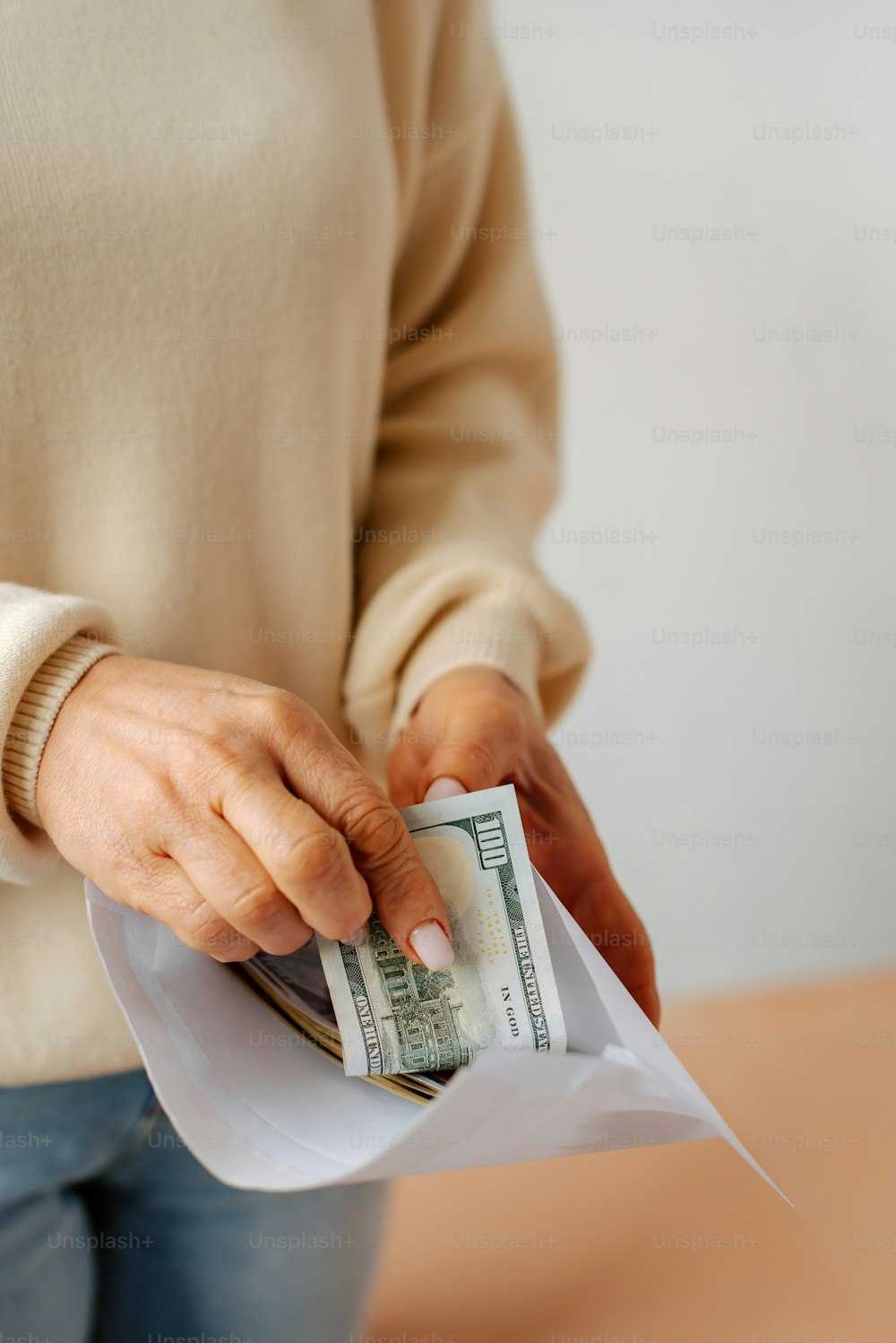a woman putting money into a white envelope