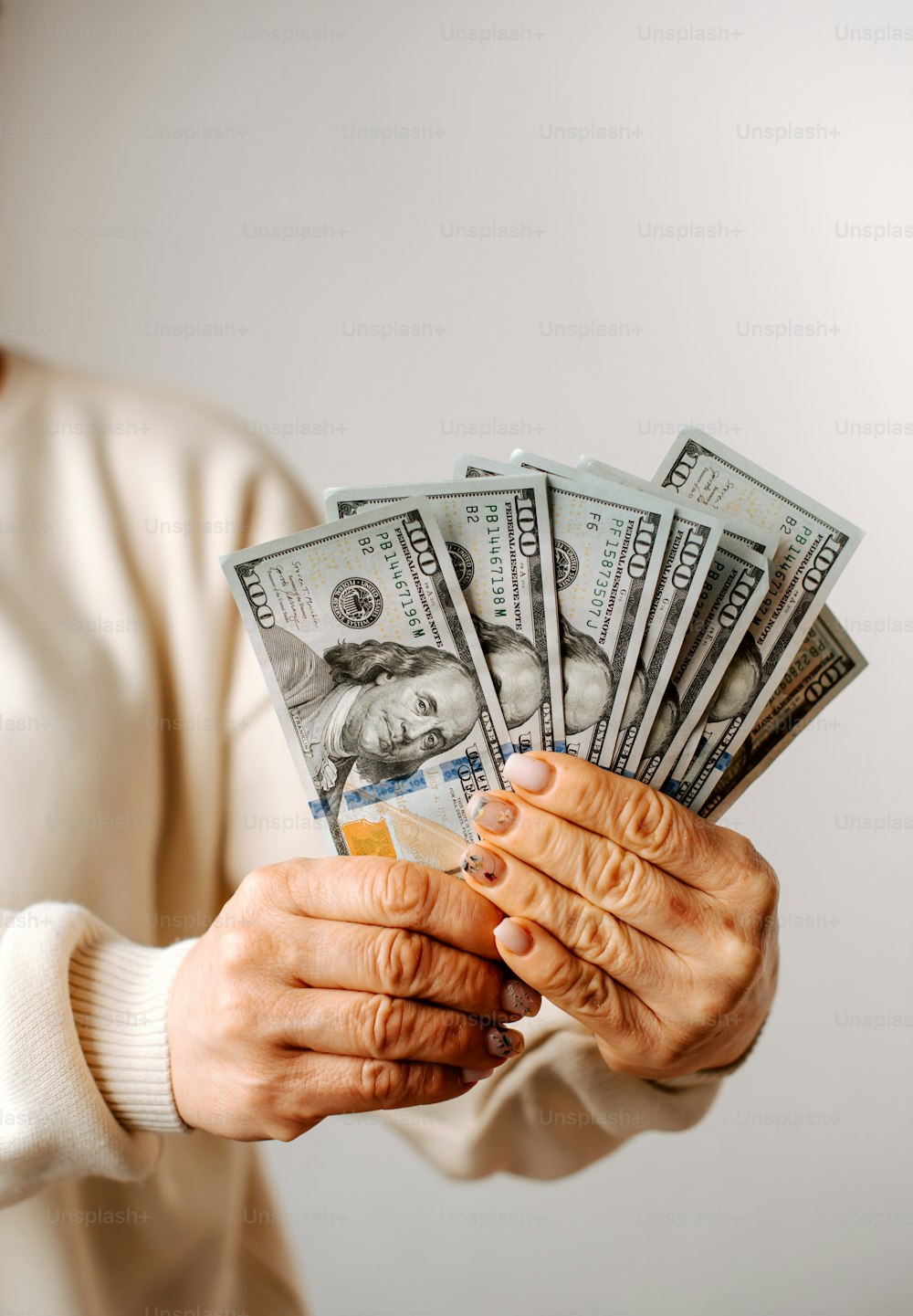 a woman holding a bundle of money in her hands