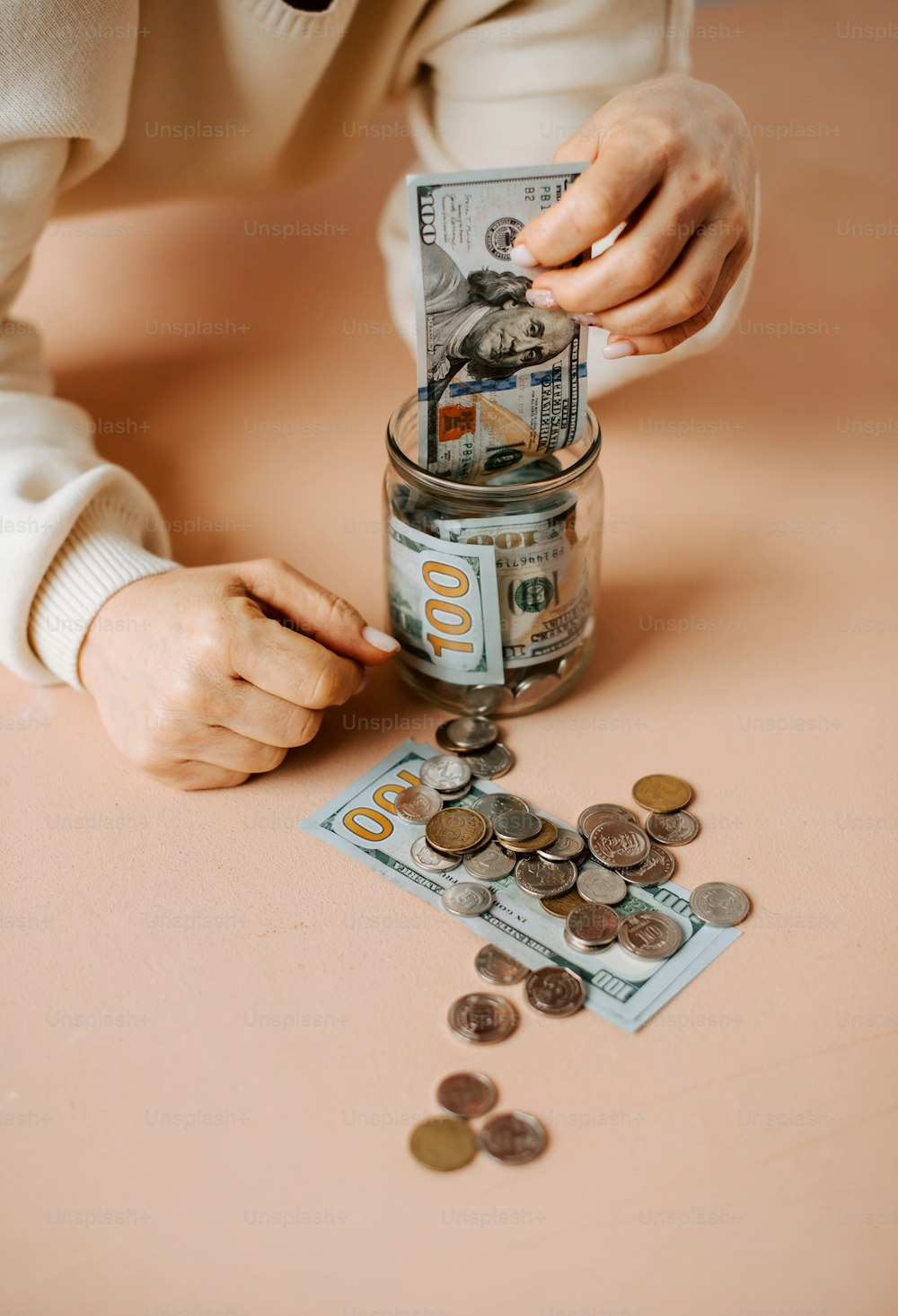 a person putting money into a jar