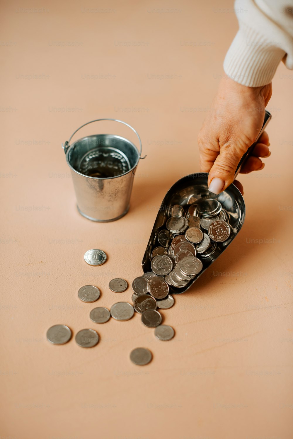 uma pessoa colocando moedas em um balde