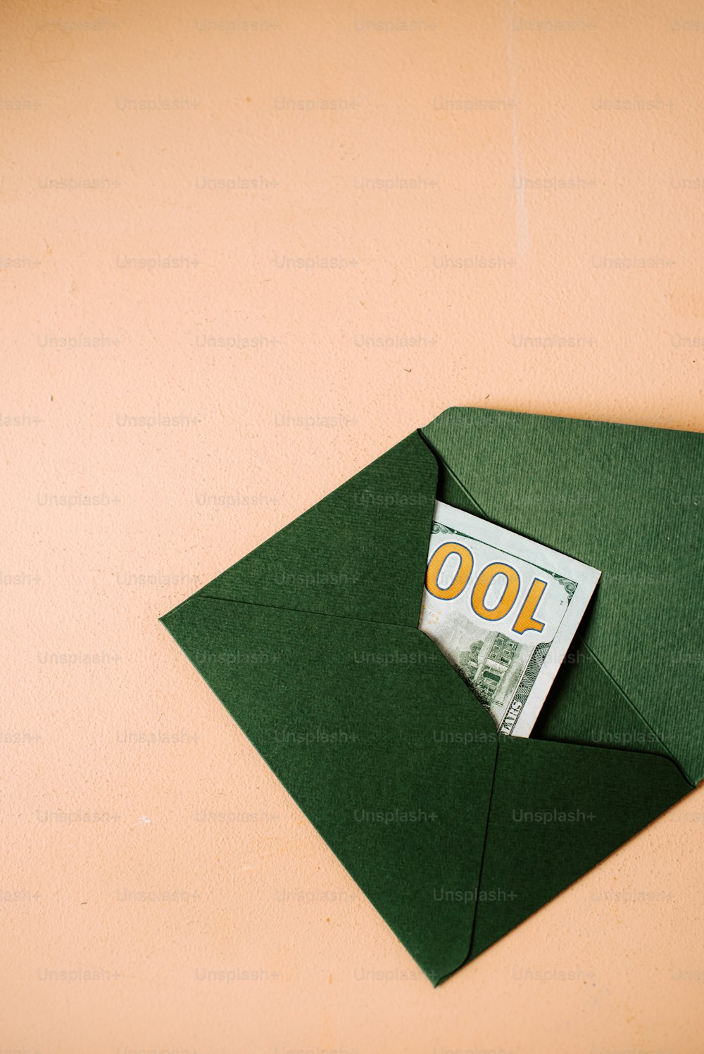 um envelope verde com uma nota de cem dólares saindo dele