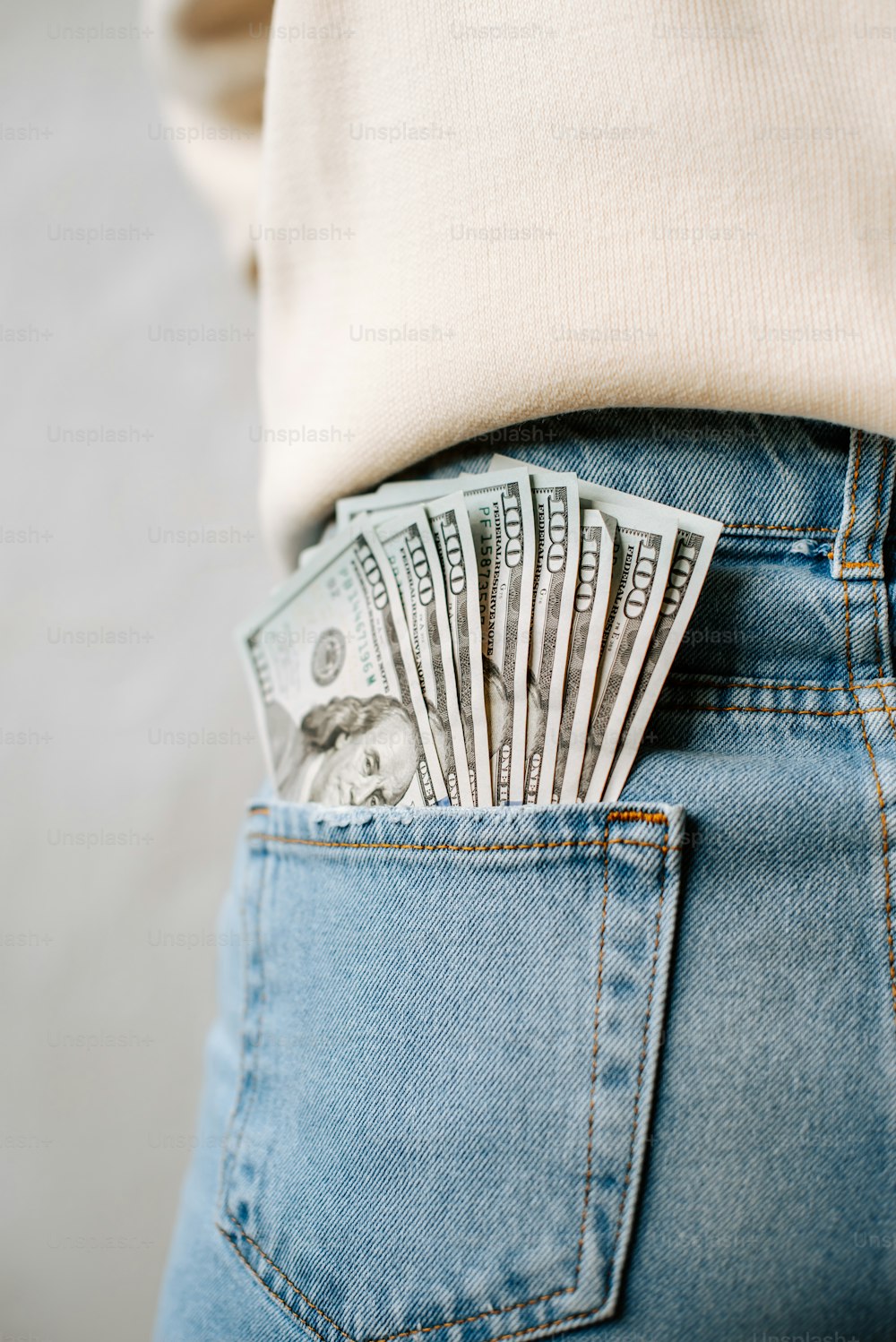 a person in a white shirt is holding money in their back pocket