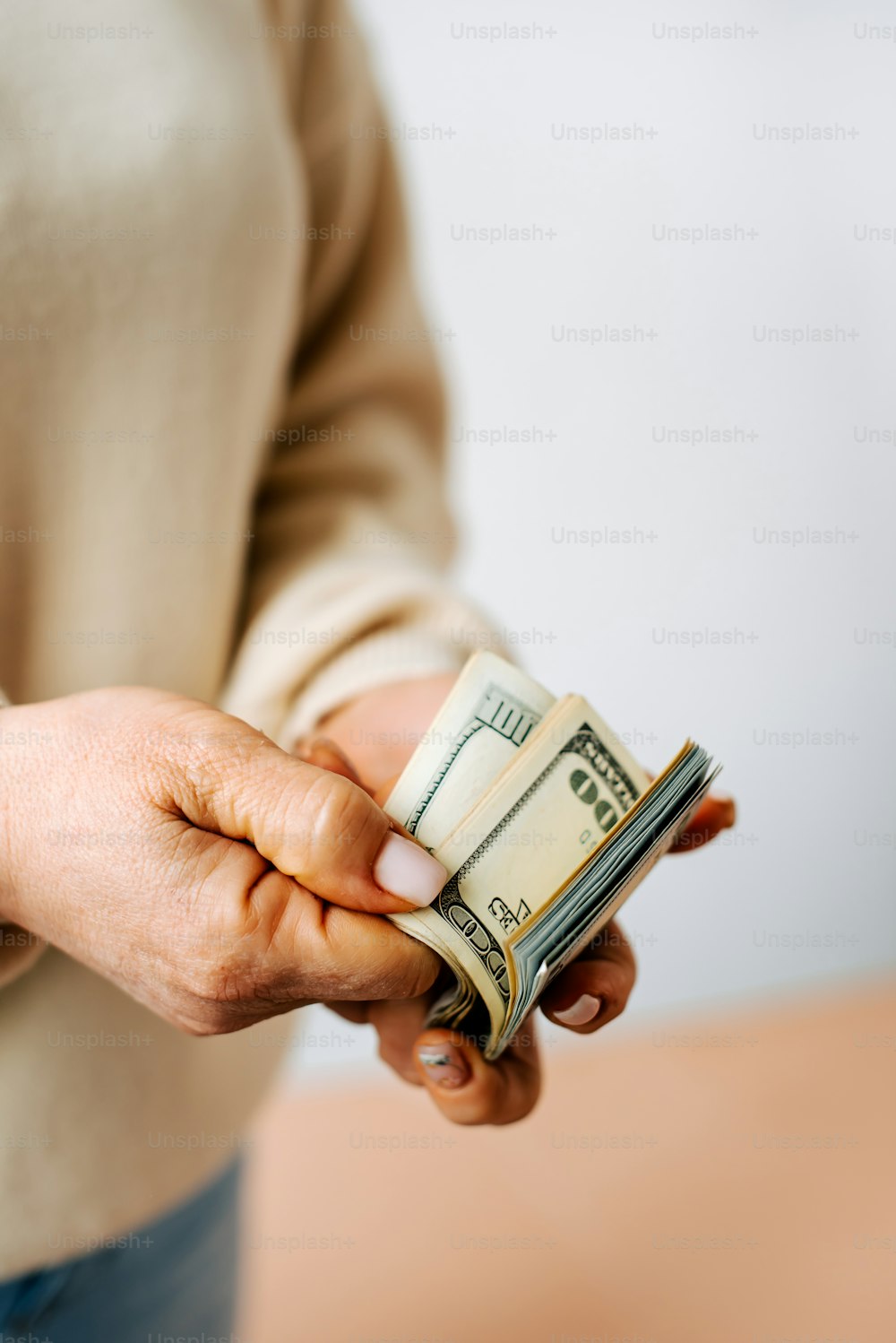 a woman holding a stack of money in her hand