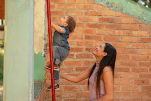 a woman holding a child up to a pole