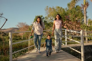 a woman and two children walking across a bridge