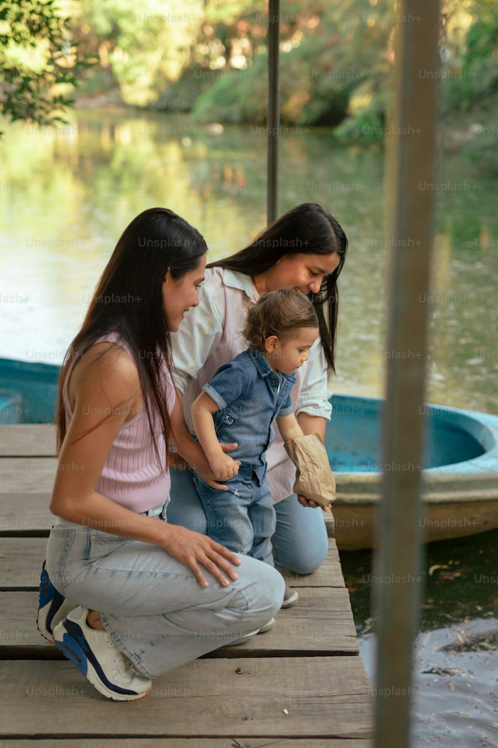 a woman and two children sitting on a dock