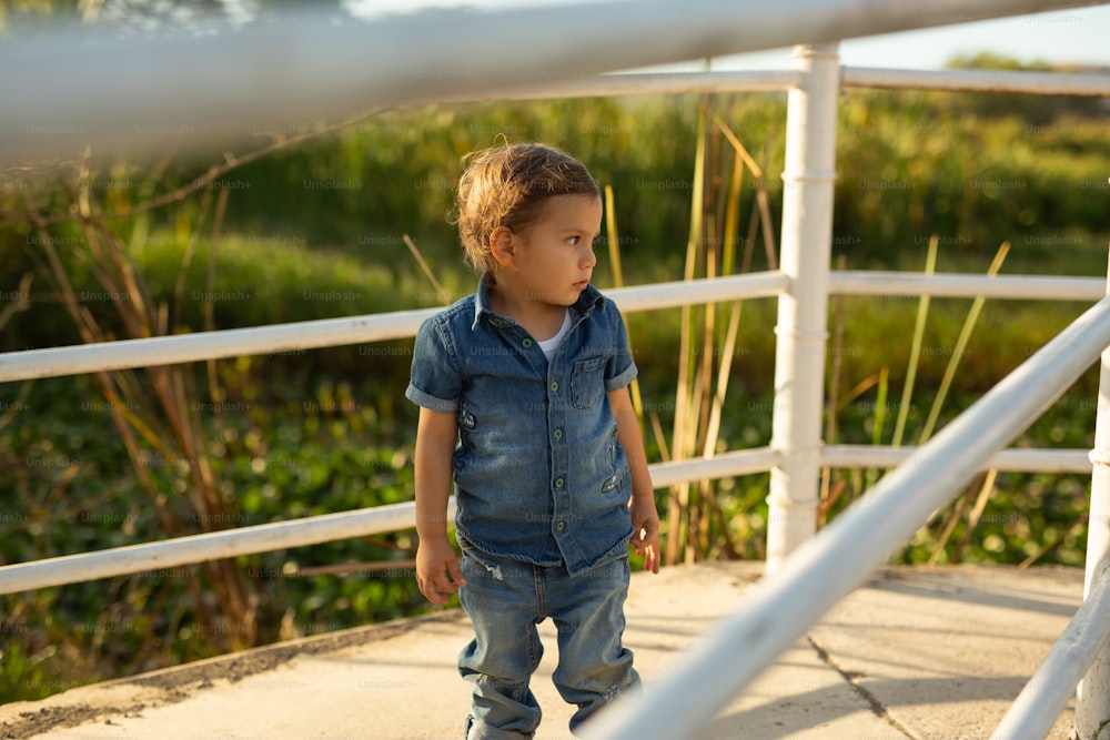 a little boy that is standing on a sidewalk