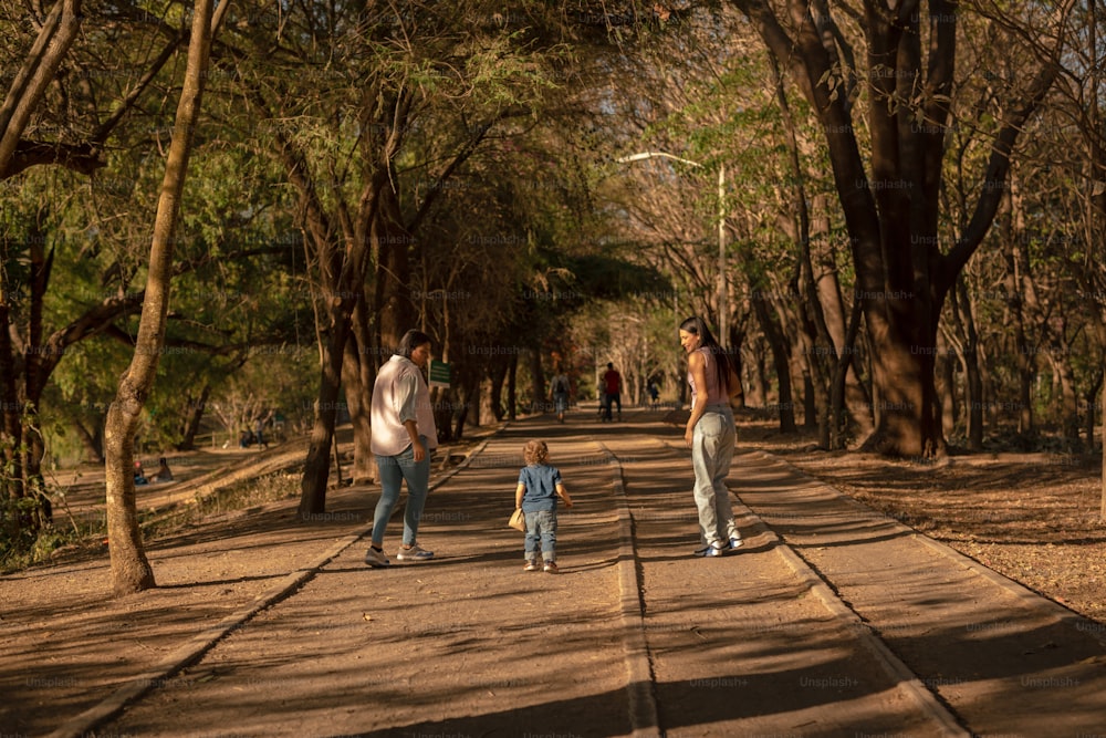 a group of people walking down a tree lined road