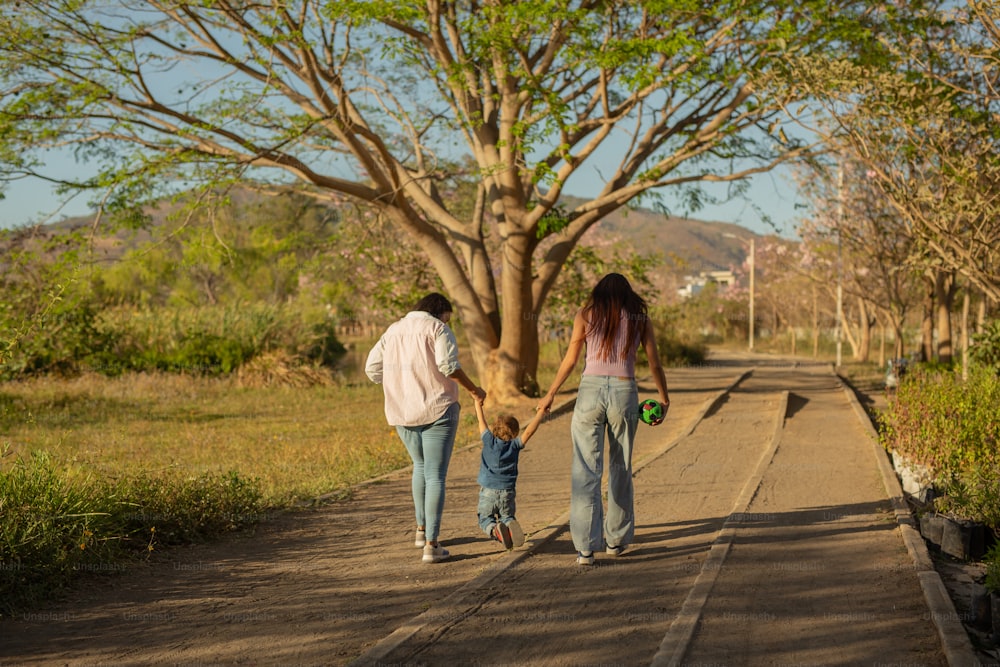 uma mulher e duas crianças andando por uma estrada