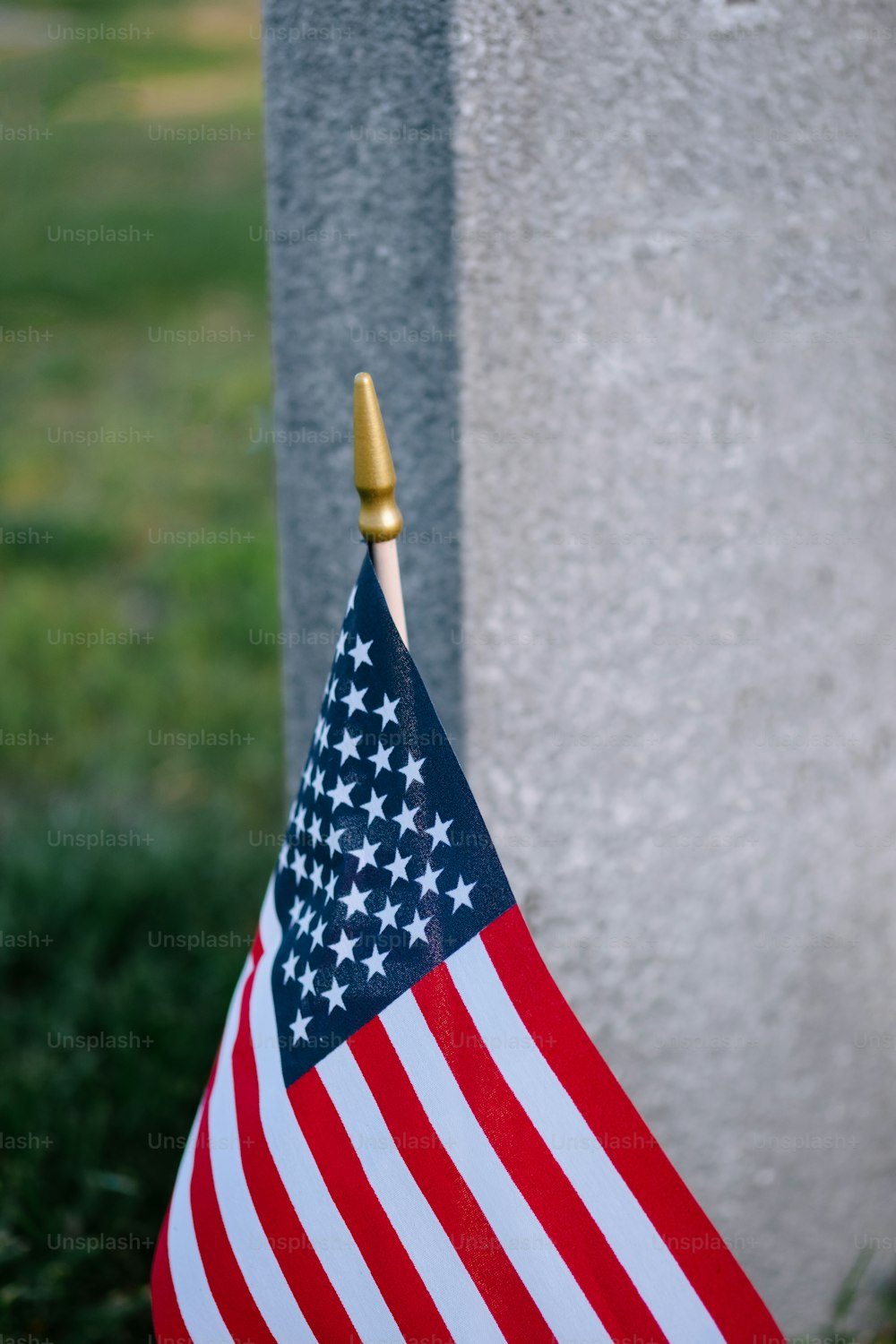 Una pequeña bandera estadounidense se coloca junto a una tumba