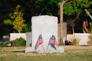 2つのアメリカ国旗が墓の前に置かれています