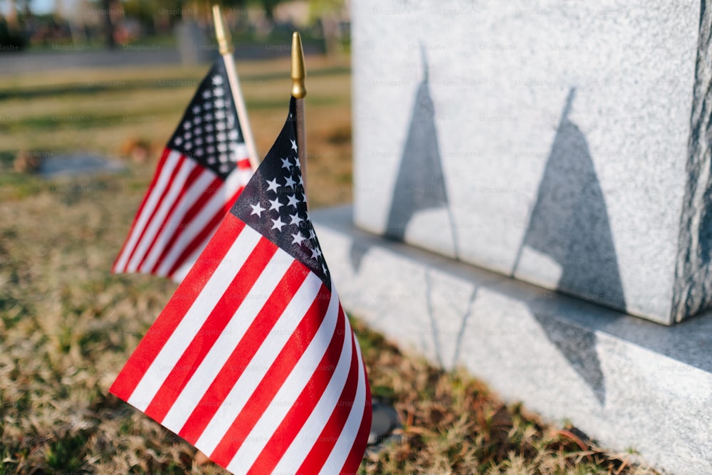 記念碑の隣に2つのアメリカ国旗が置かれています