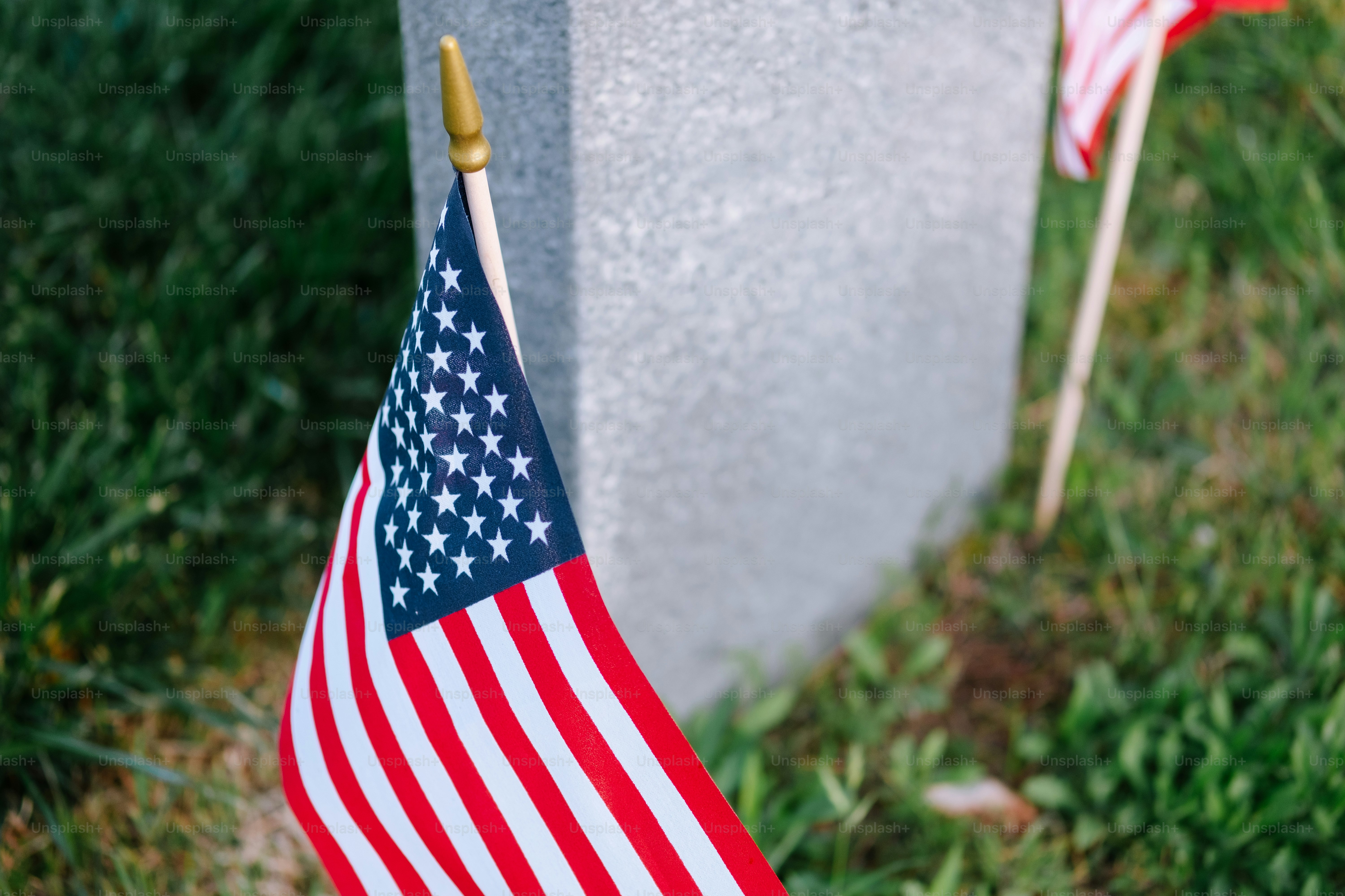 Two american flags are placed next to a grave photo – Memorial day