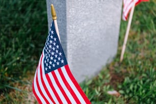 two american flags are placed next to a grave