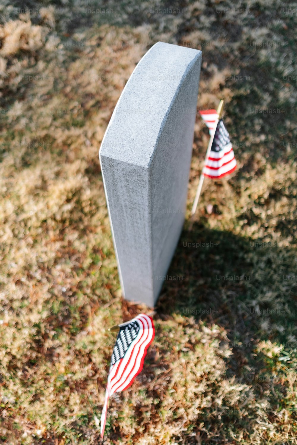 a grave with two american flags on top of it