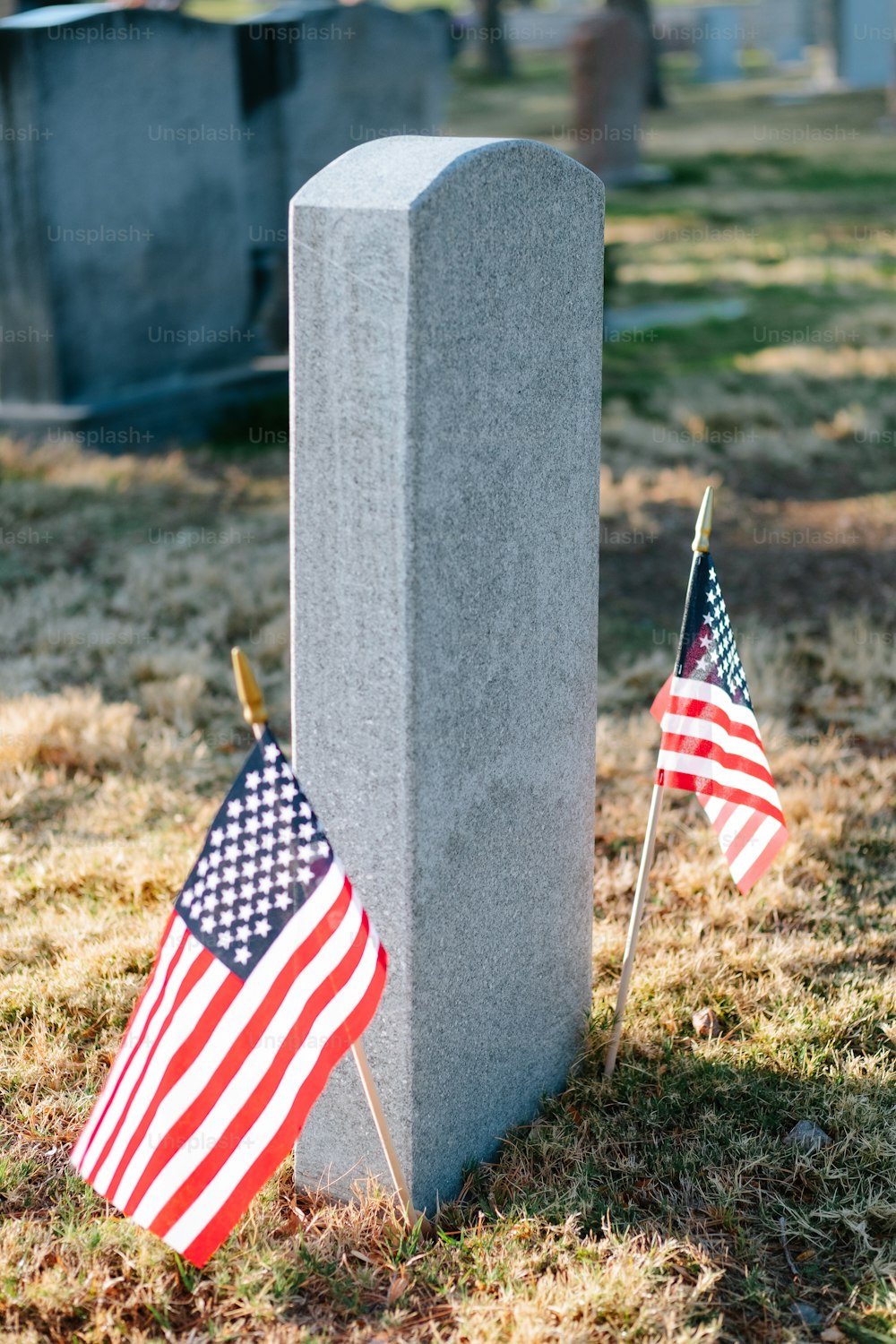 Dos banderas estadounidenses se colocan junto a una tumba