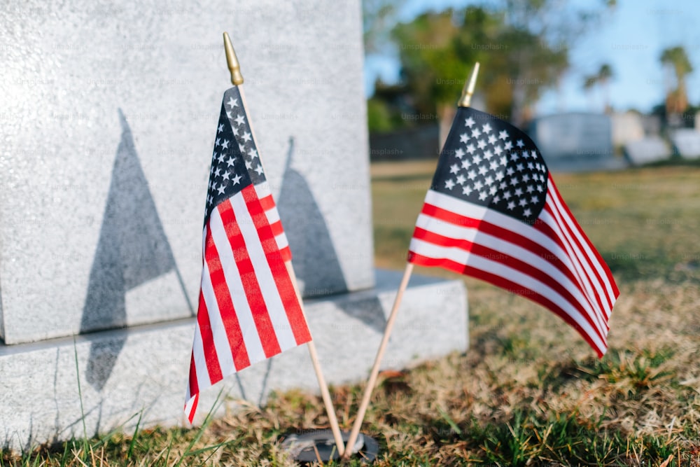 two american flags are placed next to a monument
