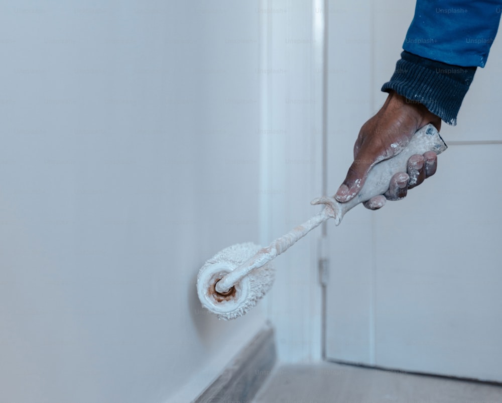 a person using a mop to clean a wall