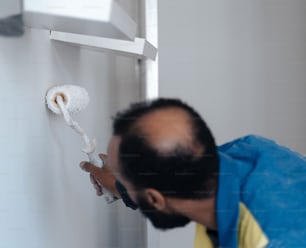 a man in overalls and a blue apron is holding a roll of toilet paper