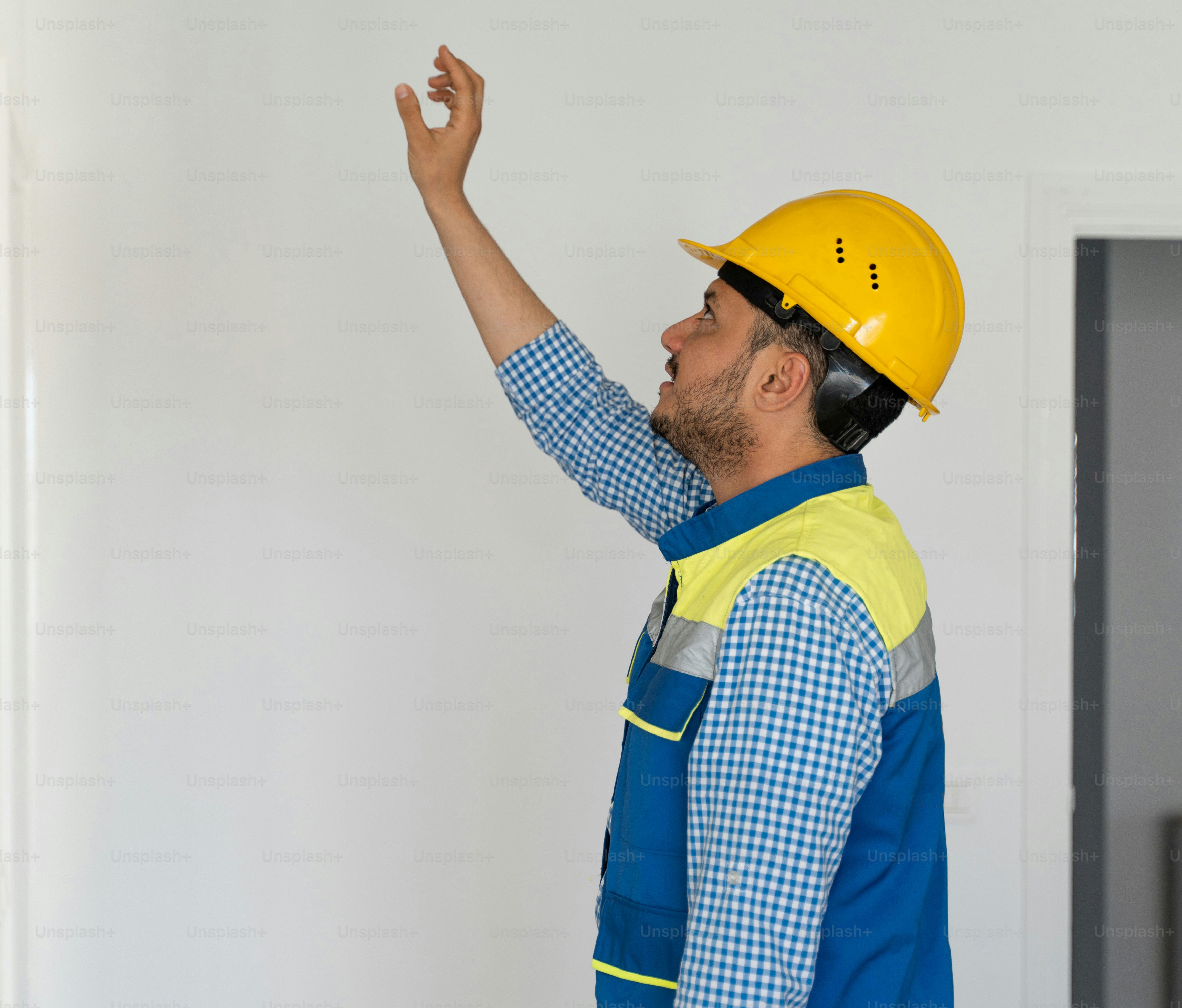 a man in a hard hat points at something