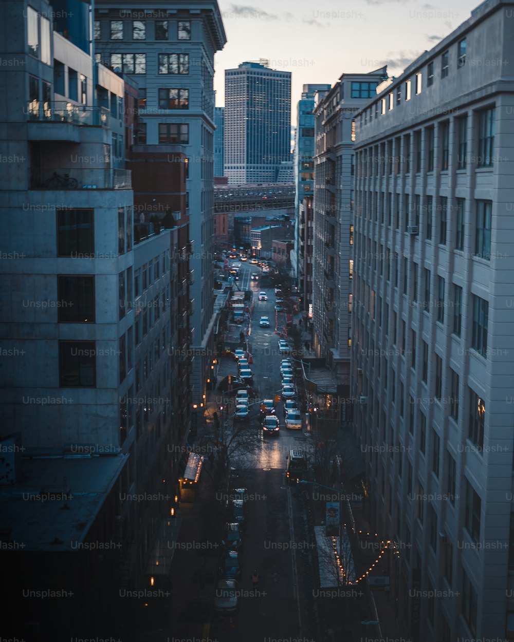 a city street filled with lots of traffic next to tall buildings