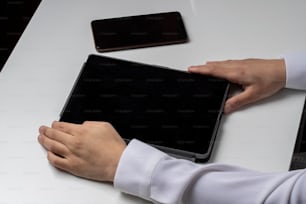 une personne assise à une table avec un ordinateur portable