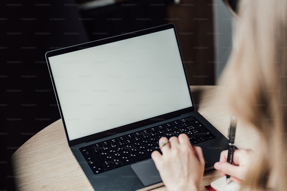 a woman sitting at a table with a laptop computer