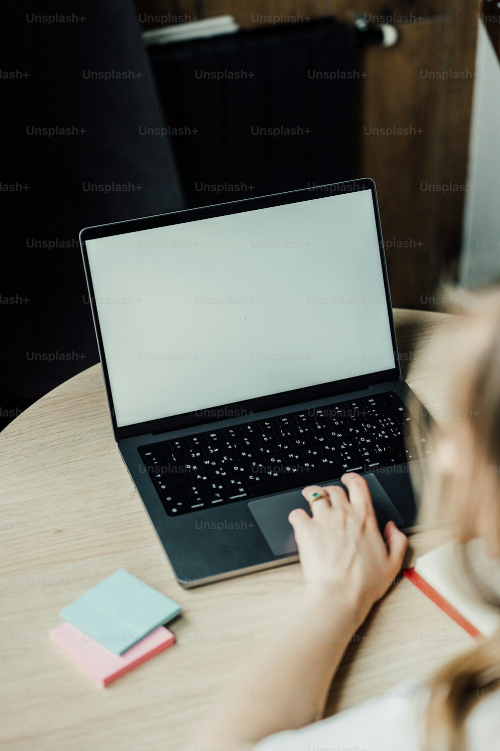 Una mujer sentada en una mesa usando una computadora portátil