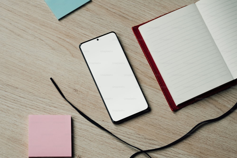 an open notebook and a cell phone on a table