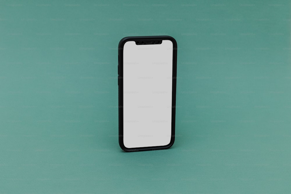 um telefone celular preto e branco sentado em cima de uma superfície verde