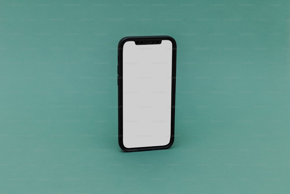 un téléphone portable noir et blanc posé sur une surface verte