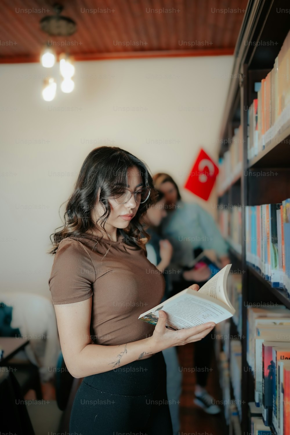 a woman reading a book in a library