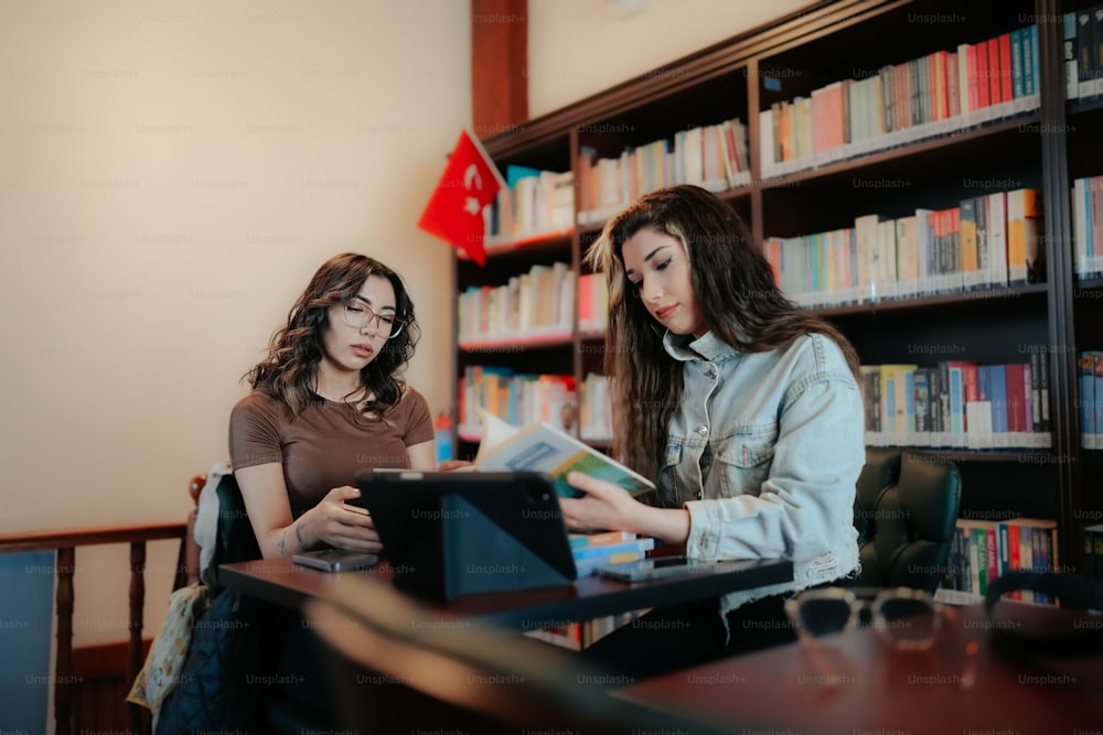 two women are looking at a book in a library