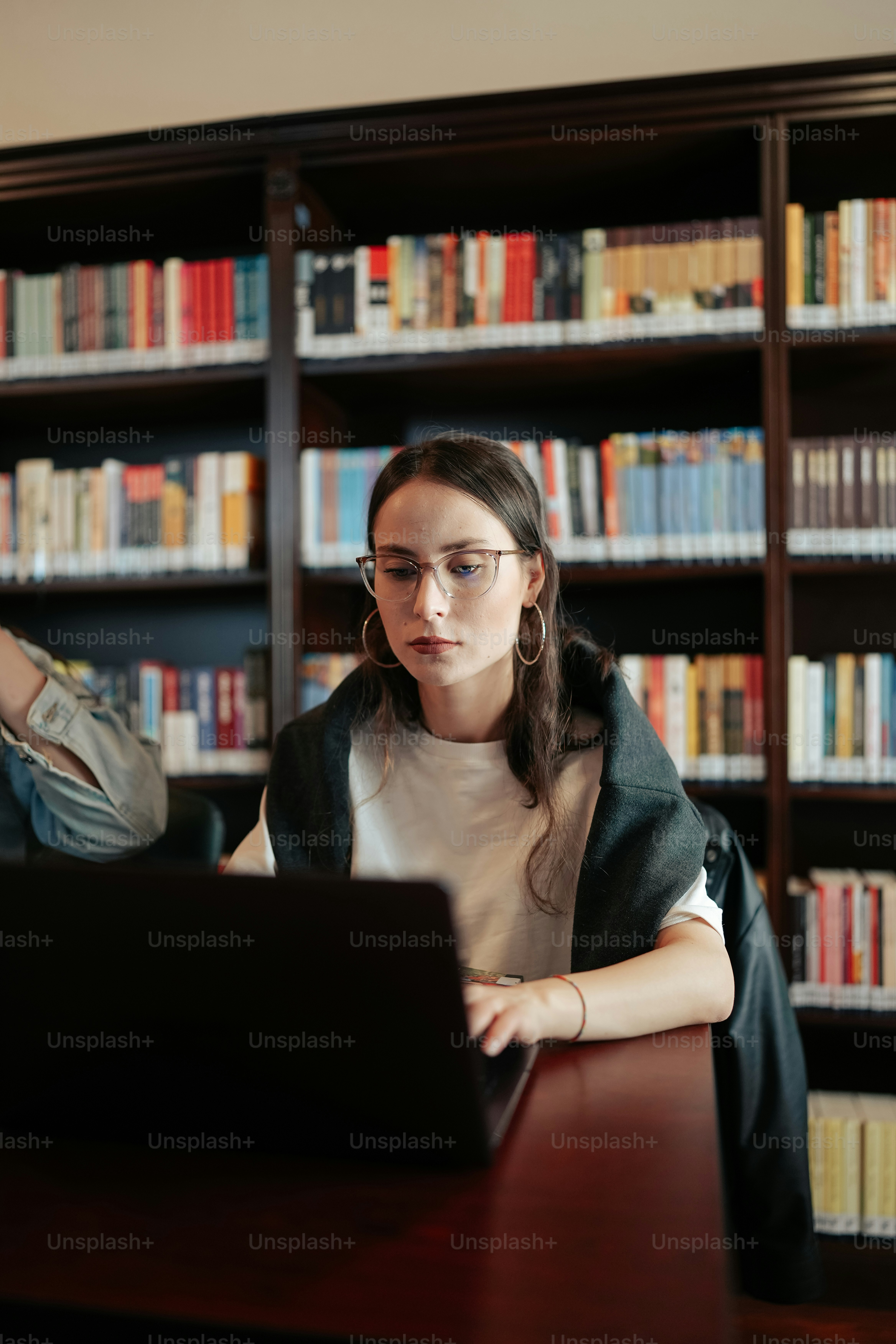 a woman sitting in front of a laptop computer